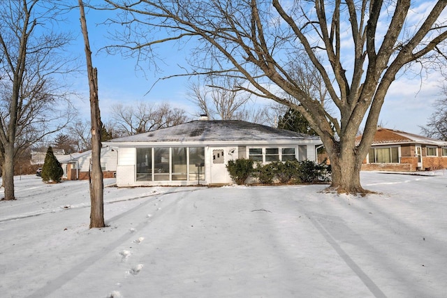 view of front facade with brick siding and a sunroom