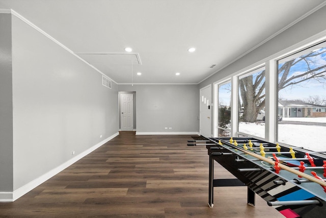 rec room with visible vents, baseboards, attic access, ornamental molding, and wood finished floors