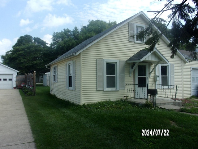 bungalow-style house featuring a front lawn, an outbuilding, and a garage