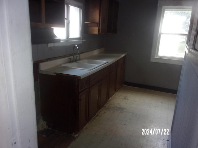 kitchen featuring a sink, light floors, a healthy amount of sunlight, and light countertops