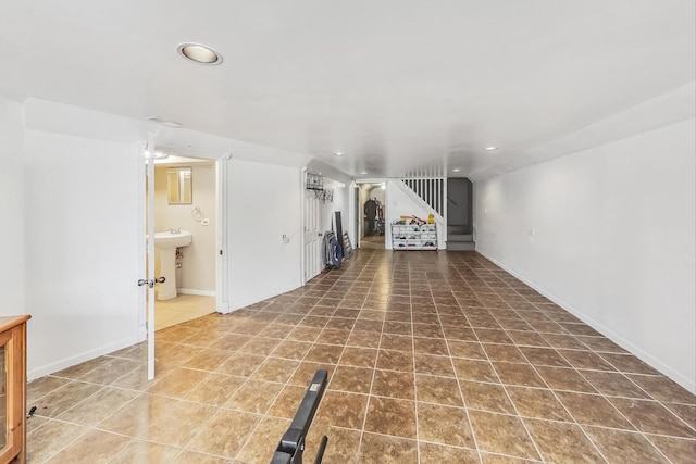 unfurnished living room featuring tile patterned flooring, stairway, lofted ceiling, recessed lighting, and a sink