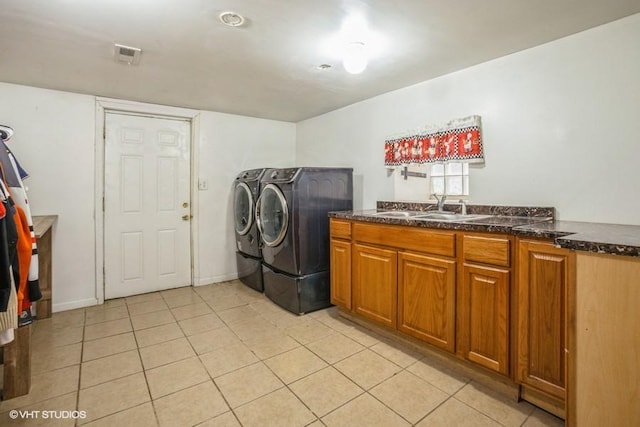 laundry room with visible vents, washer and clothes dryer, a sink, cabinet space, and light tile patterned flooring