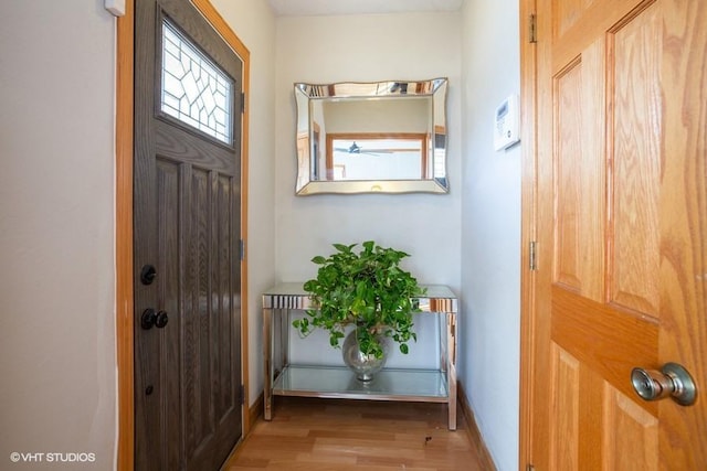 foyer with baseboards and light wood-type flooring