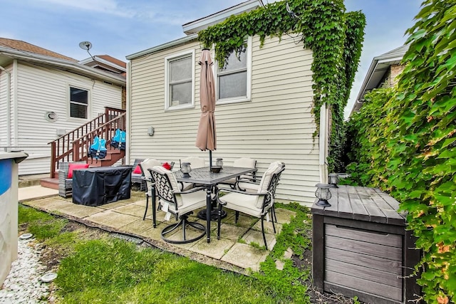 rear view of house featuring stairs and a patio