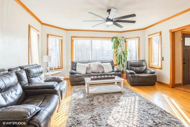 living area with ornamental molding, ceiling fan, baseboards, and wood finished floors