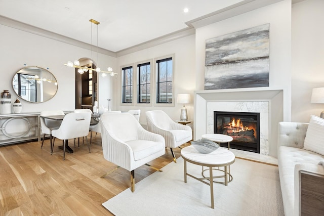 living area featuring wood finished floors, a fireplace, and ornamental molding