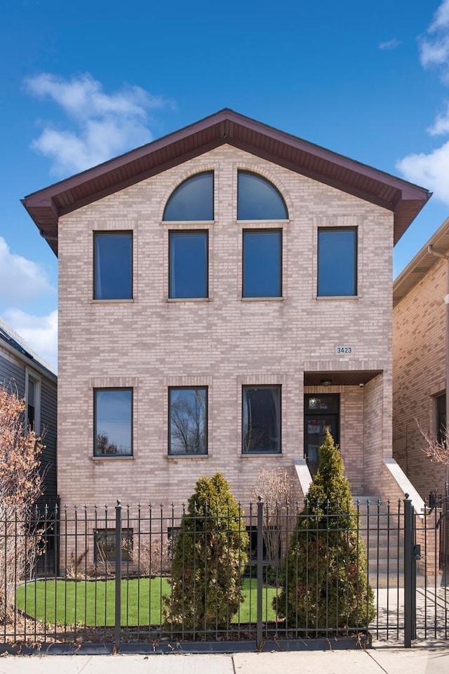 view of front of house with brick siding and a fenced front yard