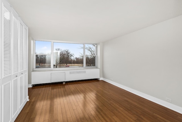 unfurnished bedroom with a closet, baseboards, and hardwood / wood-style floors