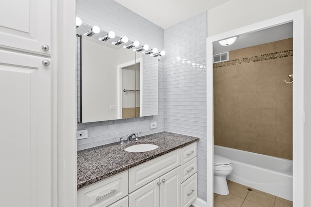 full bathroom featuring vanity, tile patterned flooring, decorative backsplash, tile walls, and toilet