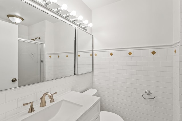 full bathroom featuring vanity, a wainscoted wall, a shower stall, tile walls, and toilet