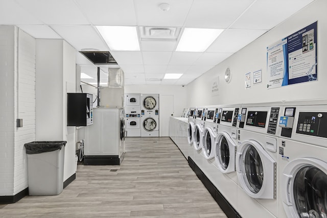 shared laundry area with visible vents, stacked washer / drying machine, light wood-style floors, and separate washer and dryer