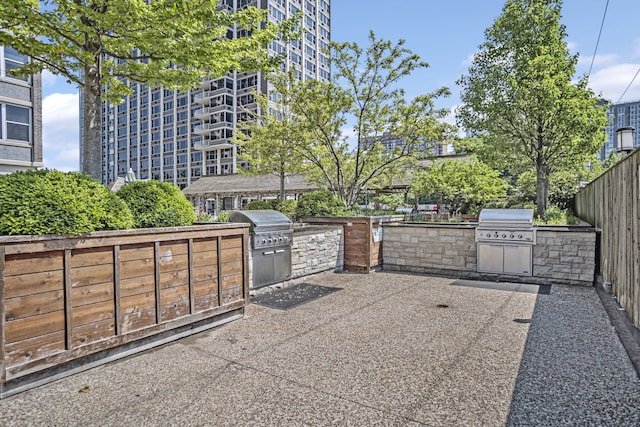 view of patio with a grill, exterior kitchen, and fence