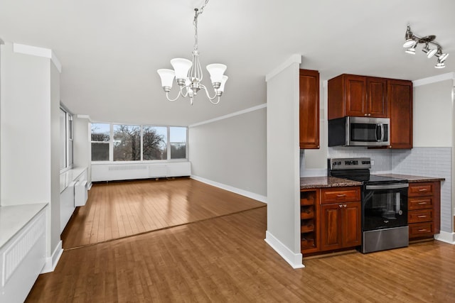 kitchen featuring appliances with stainless steel finishes, hardwood / wood-style floors, and ornamental molding