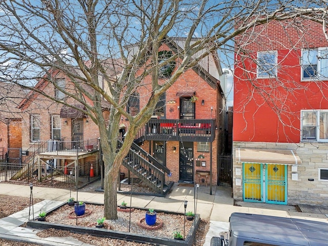 view of front of home with brick siding and stairs