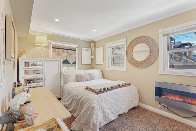 carpeted bedroom with recessed lighting, baseboards, a glass covered fireplace, and ornamental molding