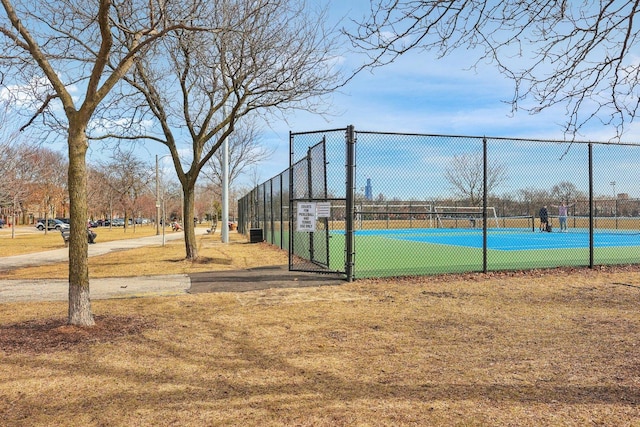 view of tennis court featuring a gate and fence