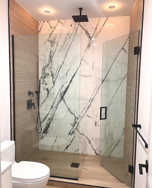 full bath with a marble finish shower, toilet, and vanity