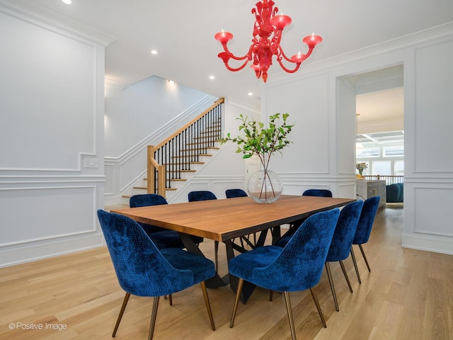 dining space featuring light wood finished floors and a decorative wall