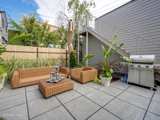 view of patio featuring an outdoor living space, area for grilling, and fence