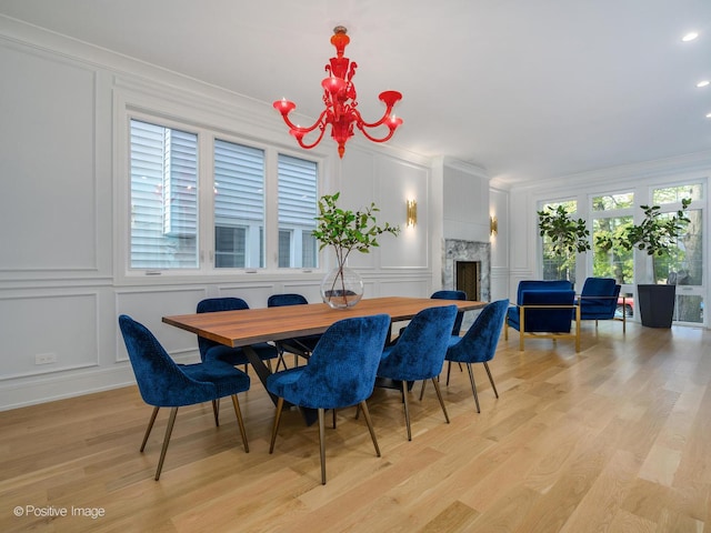 dining area with a decorative wall, a notable chandelier, and a fireplace