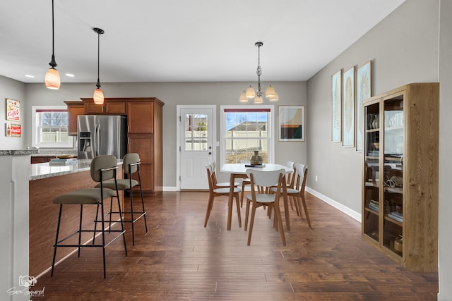 dining area featuring dark wood finished floors, baseboards, and a chandelier