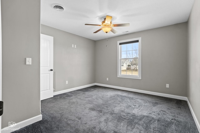 carpeted empty room with visible vents, ceiling fan, and baseboards