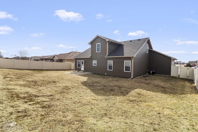 rear view of property featuring a fenced backyard, central AC, and a shingled roof