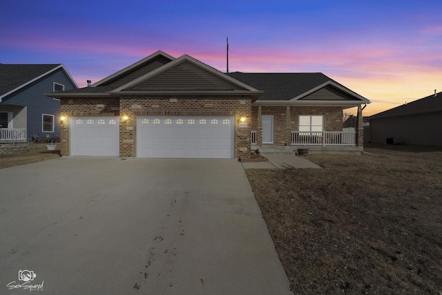 ranch-style home with brick siding, a porch, driveway, and a garage