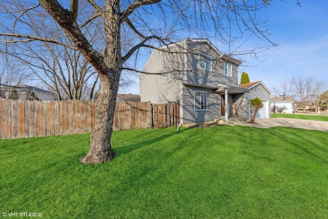 view of front facade featuring a garage, driveway, a front lawn, and fence