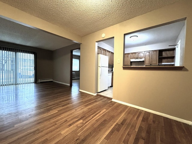 unfurnished living room featuring a healthy amount of sunlight, dark wood-type flooring, baseboards, and a baseboard radiator