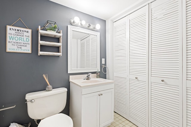 bathroom featuring a closet, toilet, and vanity