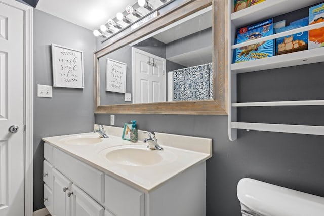 full bath featuring double vanity, toilet, and a sink