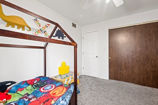 bedroom with a closet, visible vents, a ceiling fan, and carpet