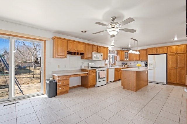 kitchen with white appliances, plenty of natural light, light countertops, and light tile patterned floors