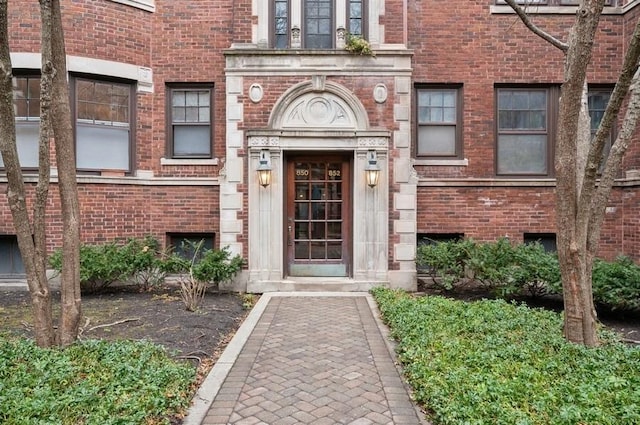 view of exterior entry featuring brick siding