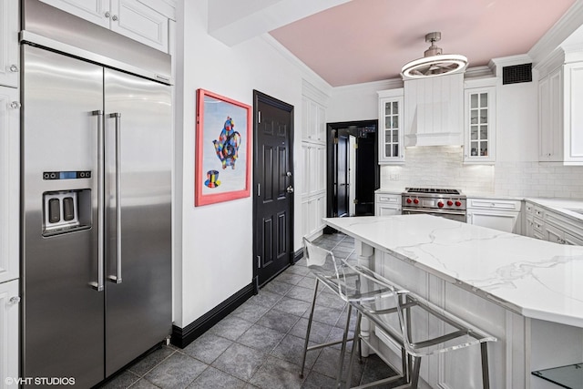 kitchen featuring backsplash, high end appliances, ornamental molding, and white cabinetry