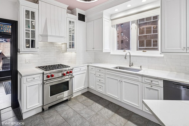 kitchen featuring luxury range, white cabinetry, dishwasher, and a sink