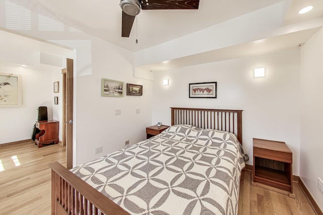 bedroom with baseboards, a ceiling fan, and light wood-style floors