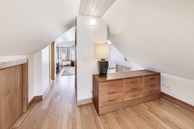 bonus room with baseboards, light wood-type flooring, and lofted ceiling