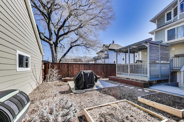 view of yard featuring central air condition unit, a vegetable garden, fence, and a wooden deck