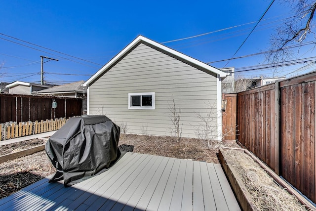 wooden terrace with a fenced backyard