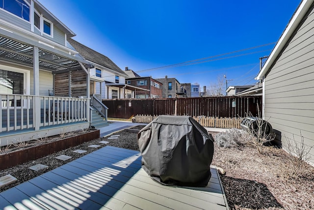 deck with grilling area, a residential view, and fence