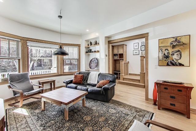 living room with recessed lighting, baseboards, built in shelves, and light wood-style flooring