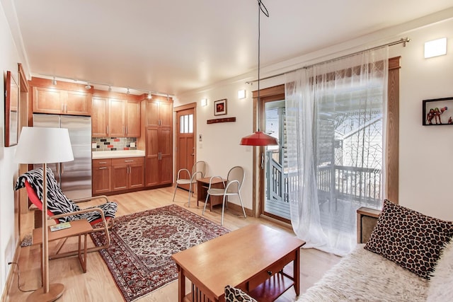 living area with light wood-style flooring and baseboards