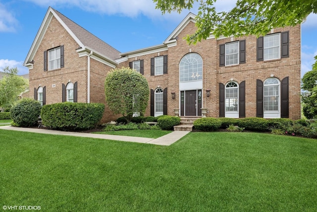 view of front of property featuring a front yard and brick siding