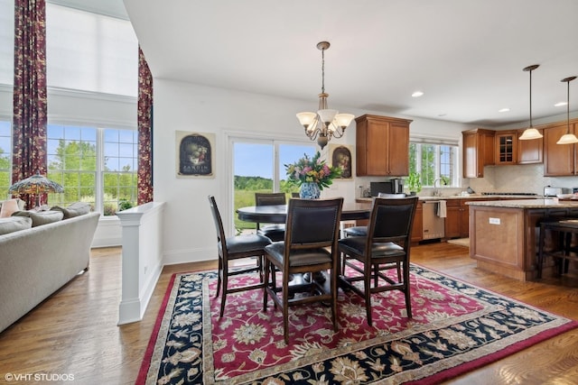 dining space featuring recessed lighting, baseboards, a notable chandelier, and light wood finished floors