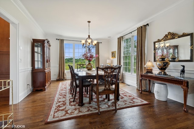 dining room featuring wainscoting, a notable chandelier, wood finished floors, and crown molding