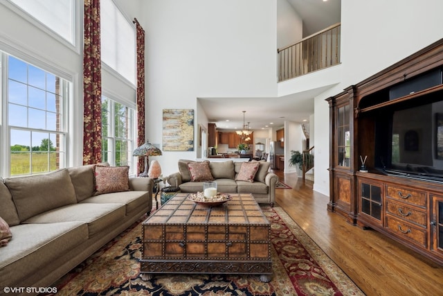 living room with wood finished floors and a towering ceiling