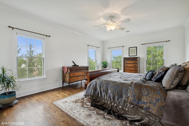 bedroom with ceiling fan, baseboards, wood finished floors, and ornamental molding