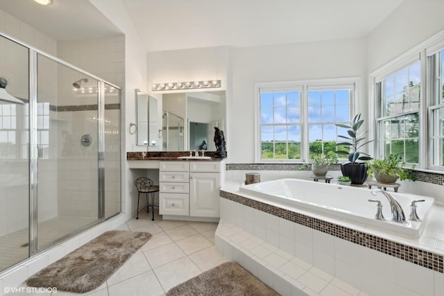 full bath featuring a wealth of natural light, a shower stall, vanity, and a garden tub